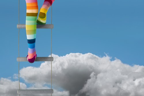 Immagine bambina calze color arcobaleno che sale una scaletta di corda