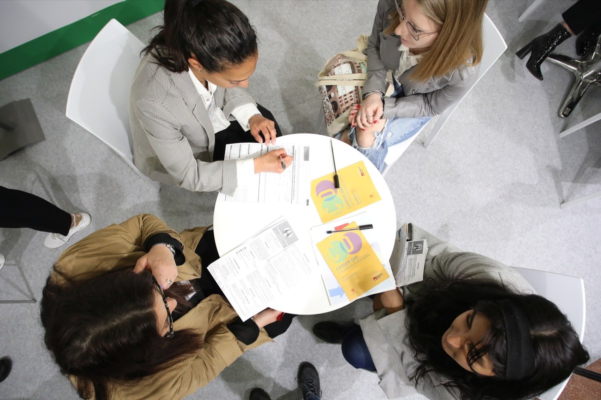 Studentesse e referenti aziendali presentano il proprio curriculum seduti a tavolino