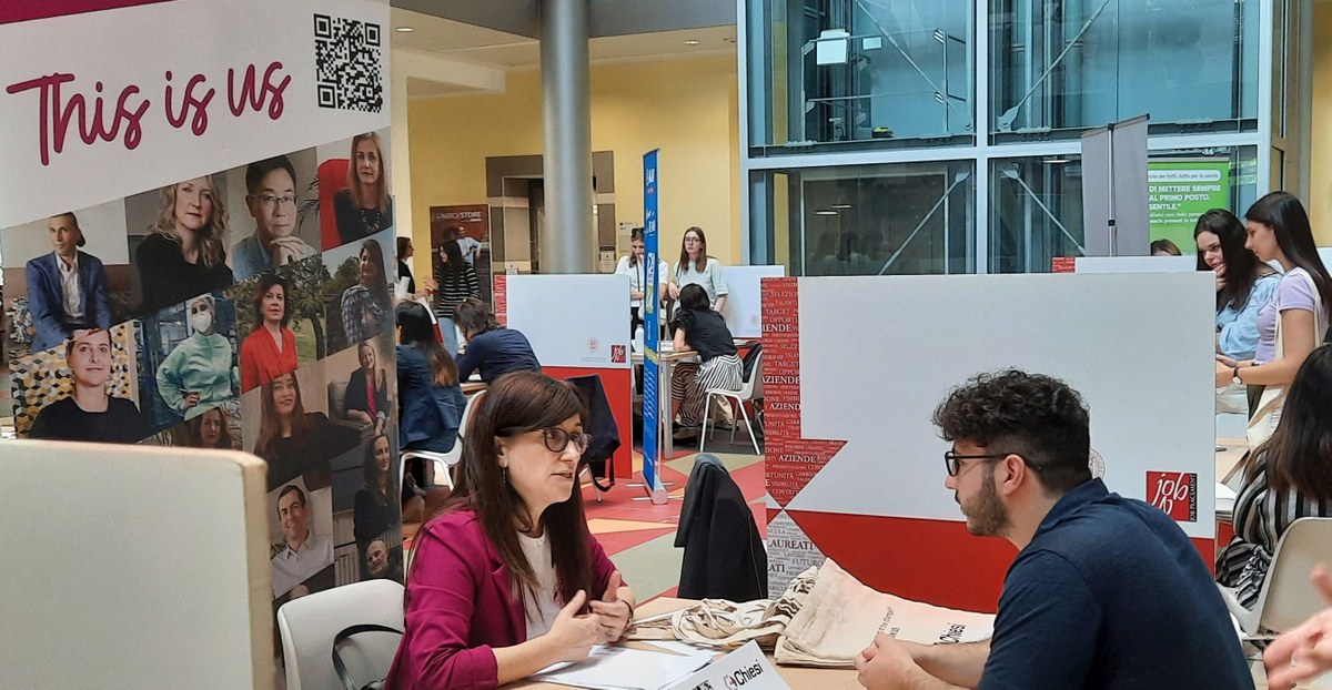 evento recruiting day con aziende e studenti che parlano ai desk evento recruiting day con aziende e studenti che parlano ai desk